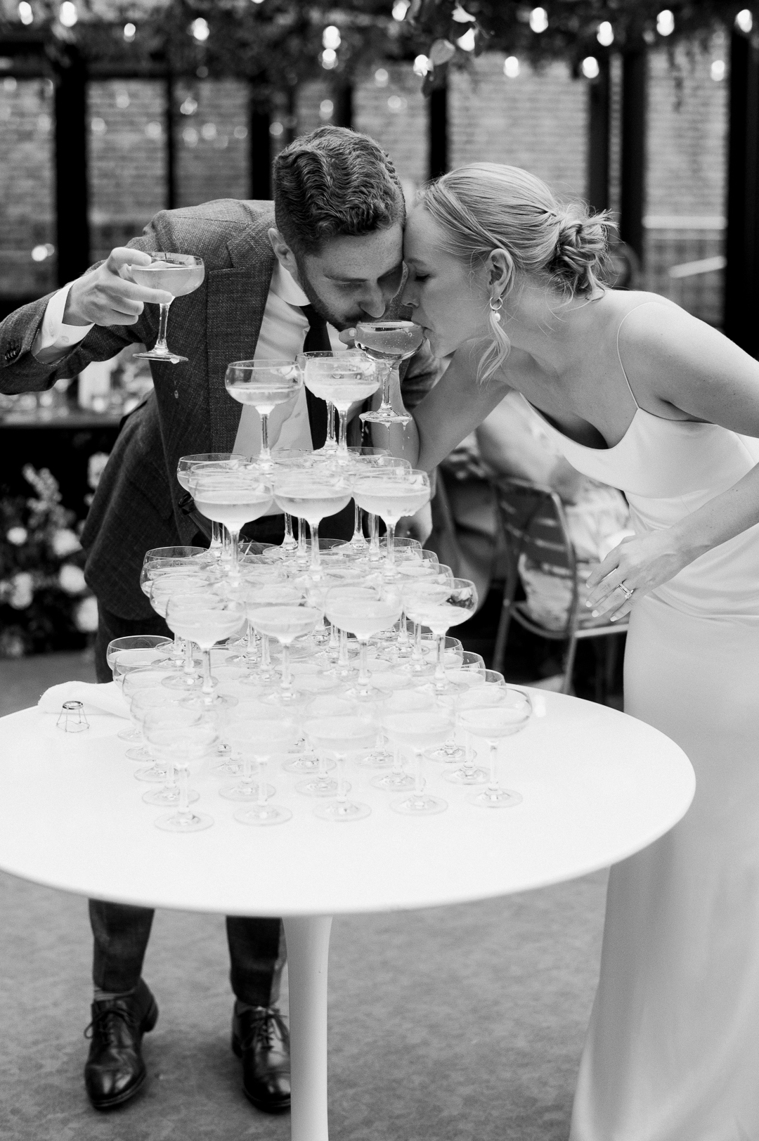 a couple drinking from their champagne tower at their wedding in chicago, illinois photographed by a luxury destination wedding photographer