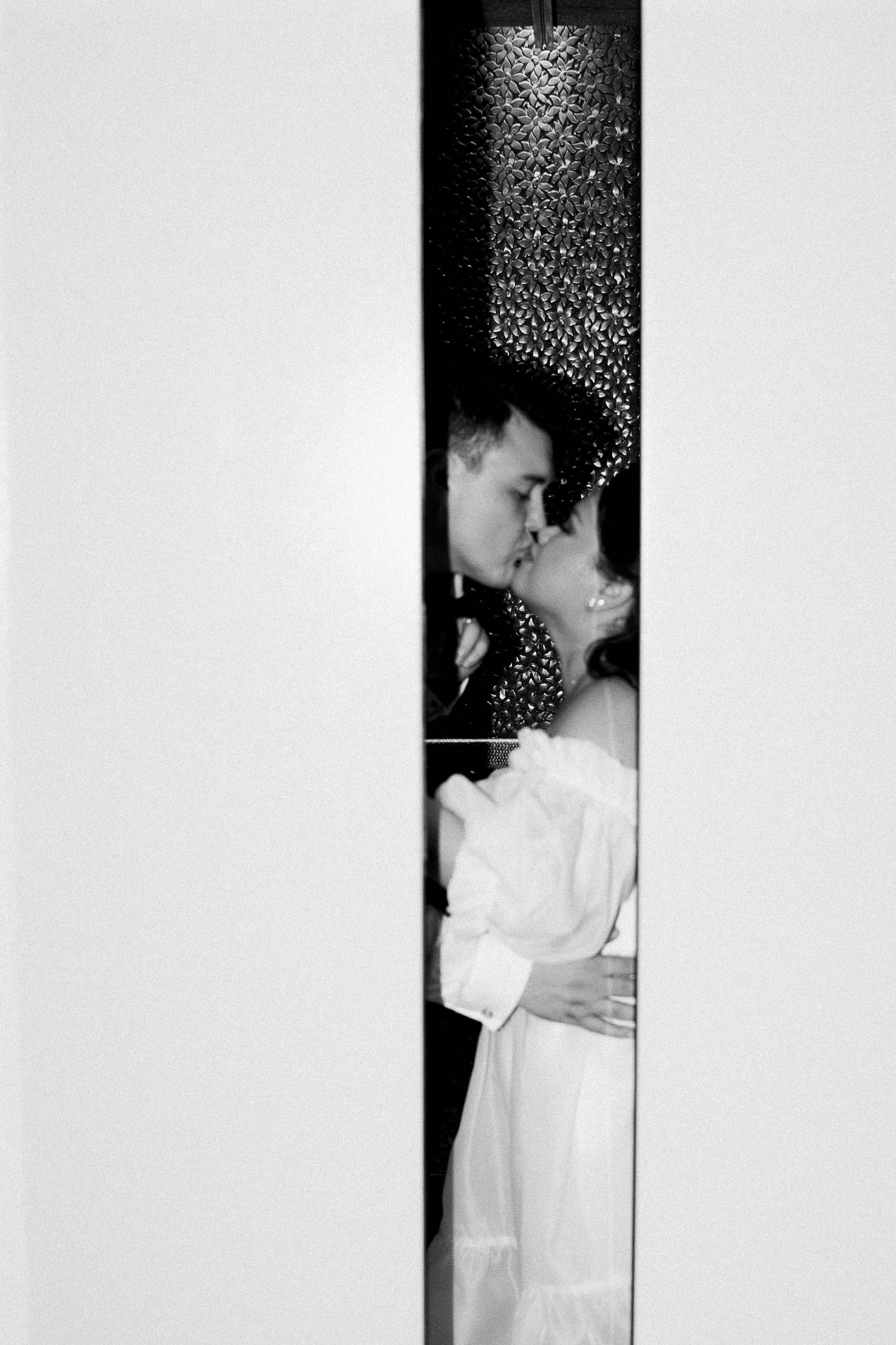 a couple kissing in the hotel elevator at the end of their destination wedding