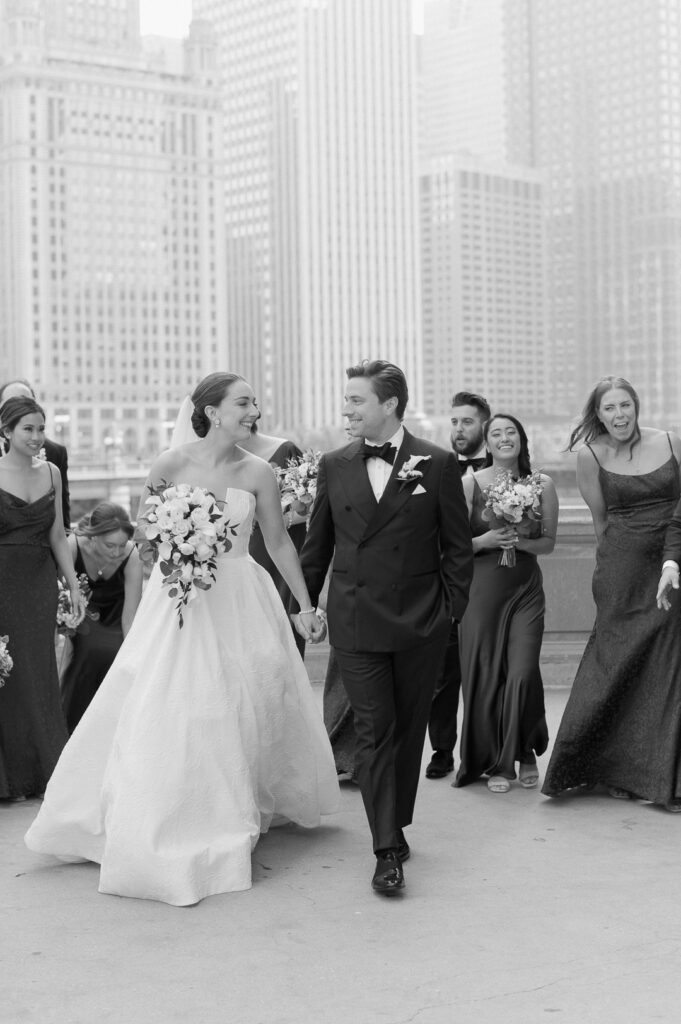 wedding party taking photos in front of the wrigley building in chicago 