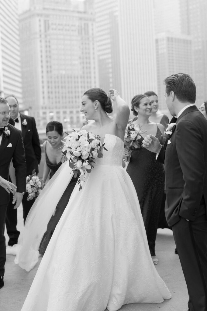 wedding party taking photos in front of the wrigley building in chicago 