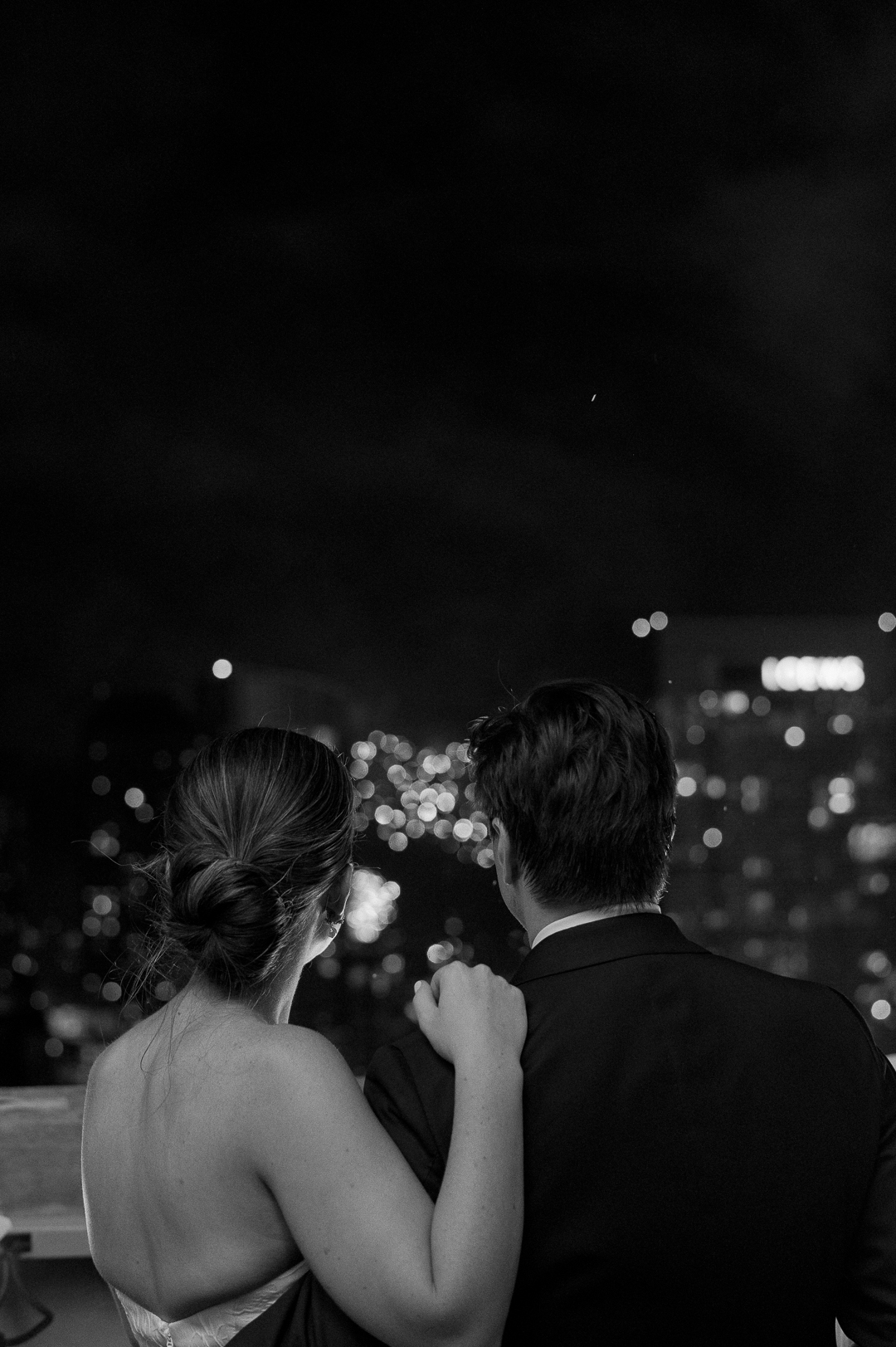 Couple watching fireworks off the roof of the Intercontinental Chicago on their wedding day